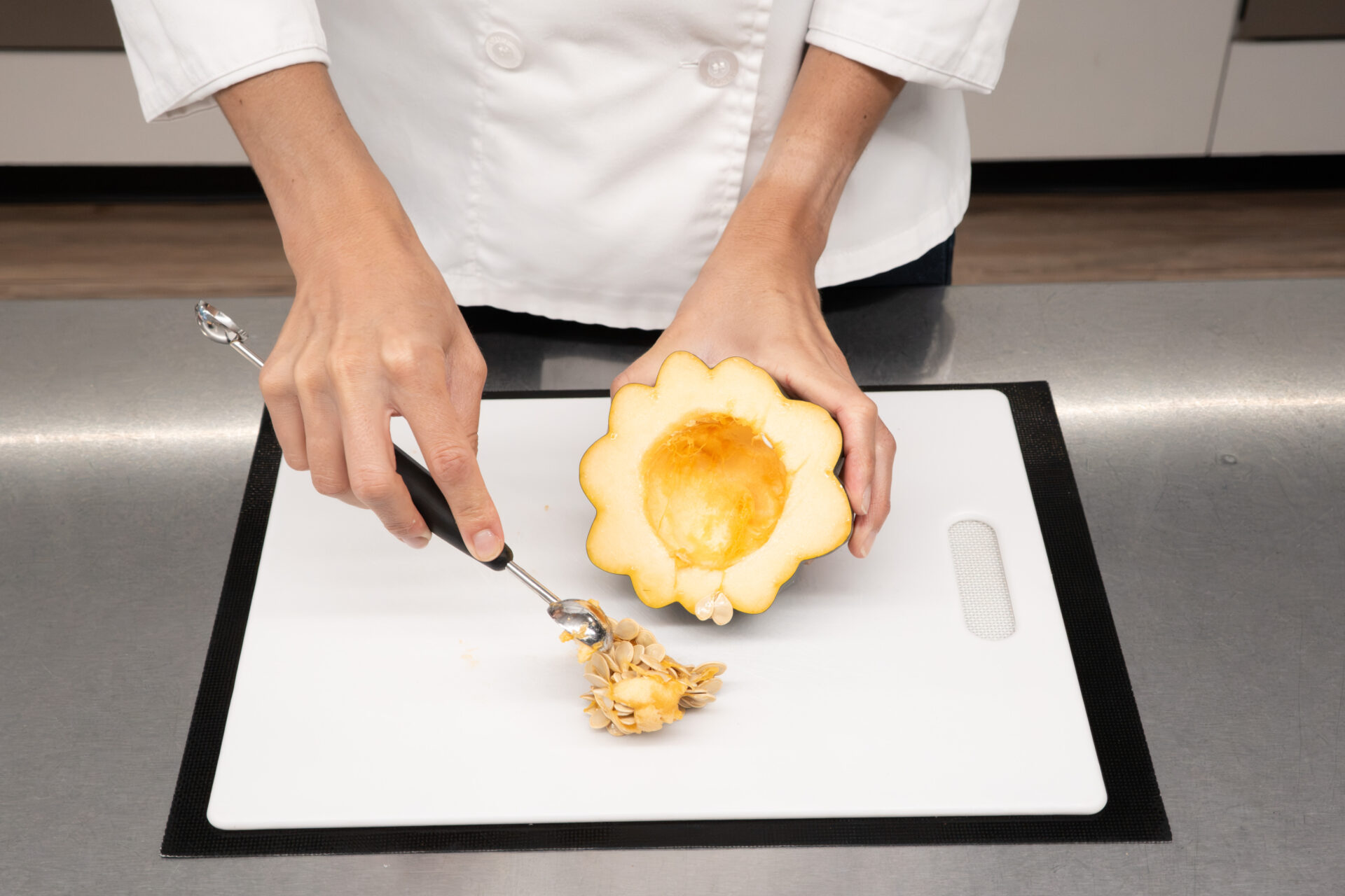 scooping seeds from acorn squash during a Montessori cooking activity