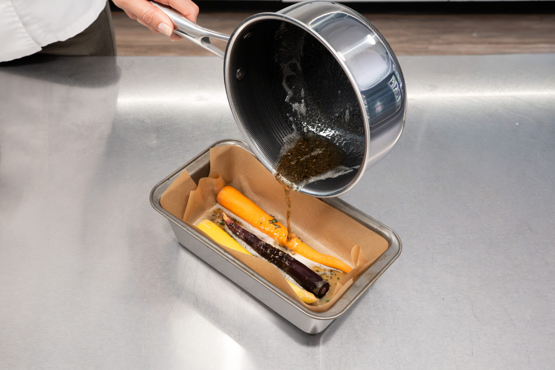 Pouring browned butter over peeled carrots during a Montessori cooking activity